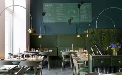 green interior of Bar Central Stockholm with tables and chairs