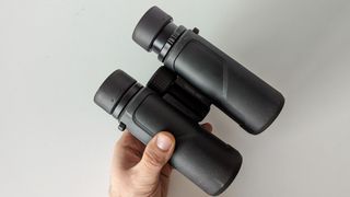 The binoculars in-hand on a white background