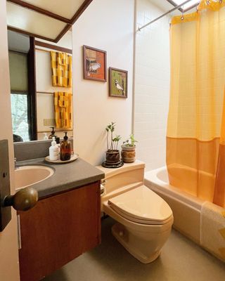 Bathroom with orange shower curtain and retro accents