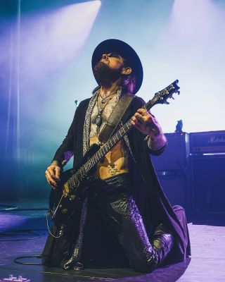 Dave Navarro on his knees, performing live with a PRS guitar