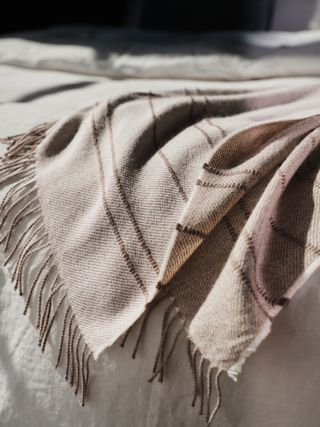 close up image of a brown and beige throw blanket on a bed