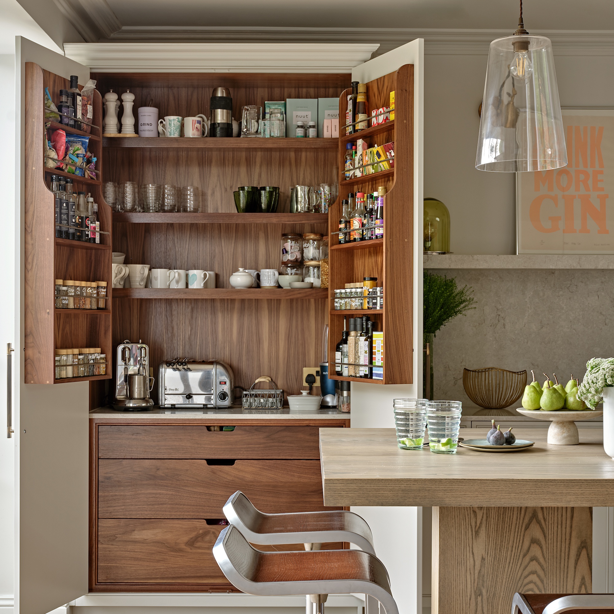 pantry cupboard in kitchen with doors of cabinet open showing breakfast appliances and coffee machine with mugs