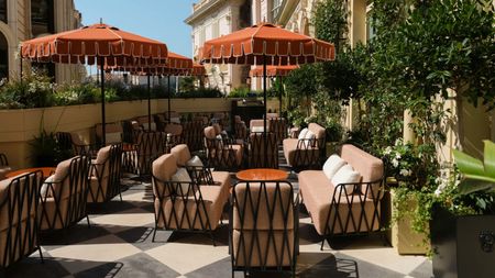  A terrace at a hotel in Monaco with checkered floors and burnt-orange parasols.