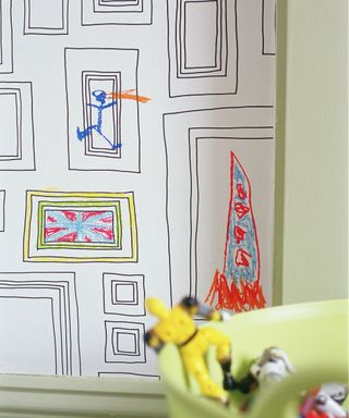 Children's drawings on the wall illustrating why you should choose washable wall finishes in boys bedroom ideas.