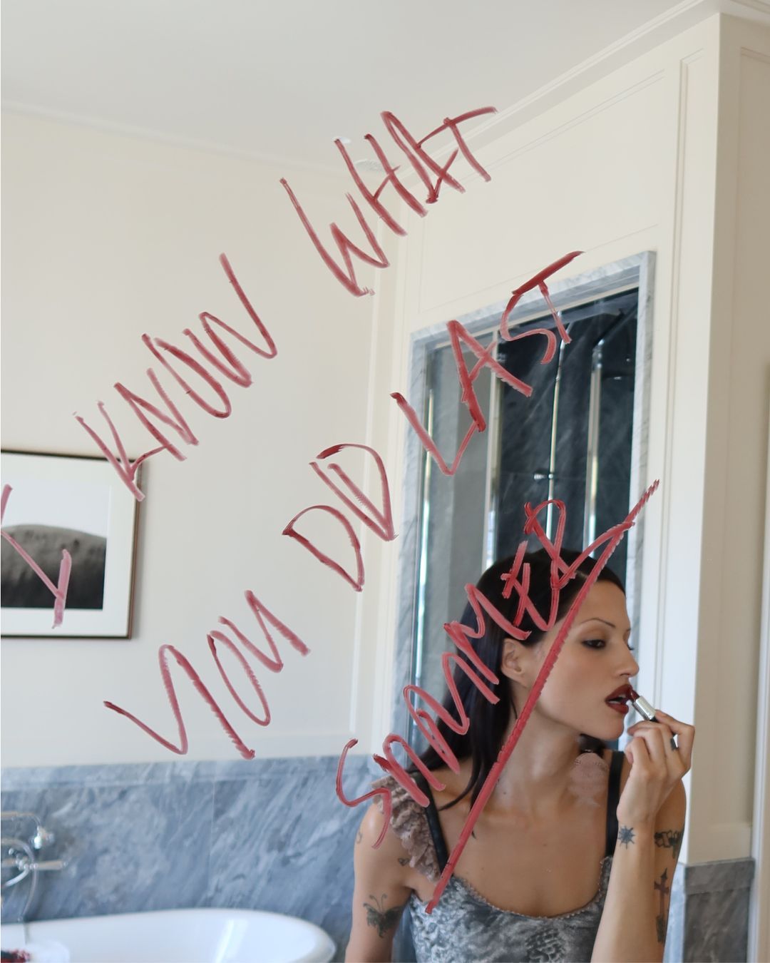 An image of Gabbriette applying her lipstick in the mirror with the words
