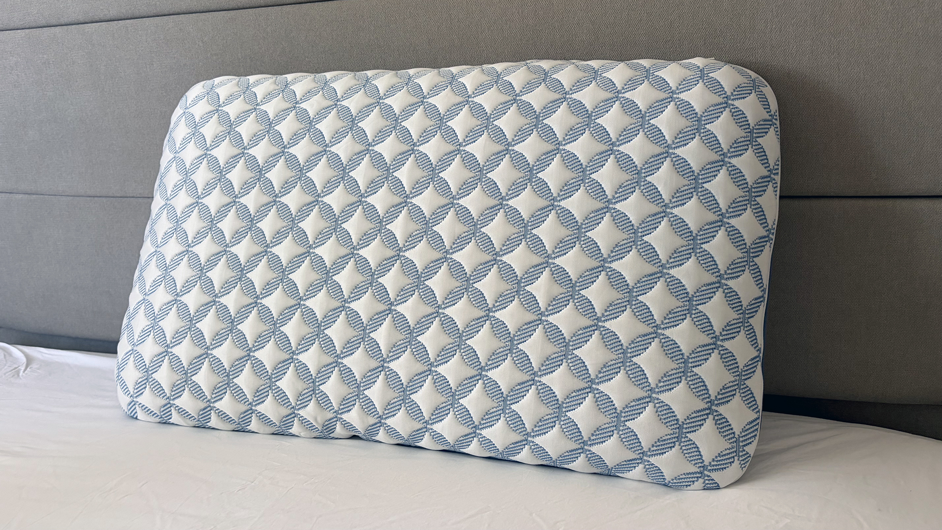 The Helix Cooling Memory Foam Pillow resting against the bed frame in our reviewer's bedroom