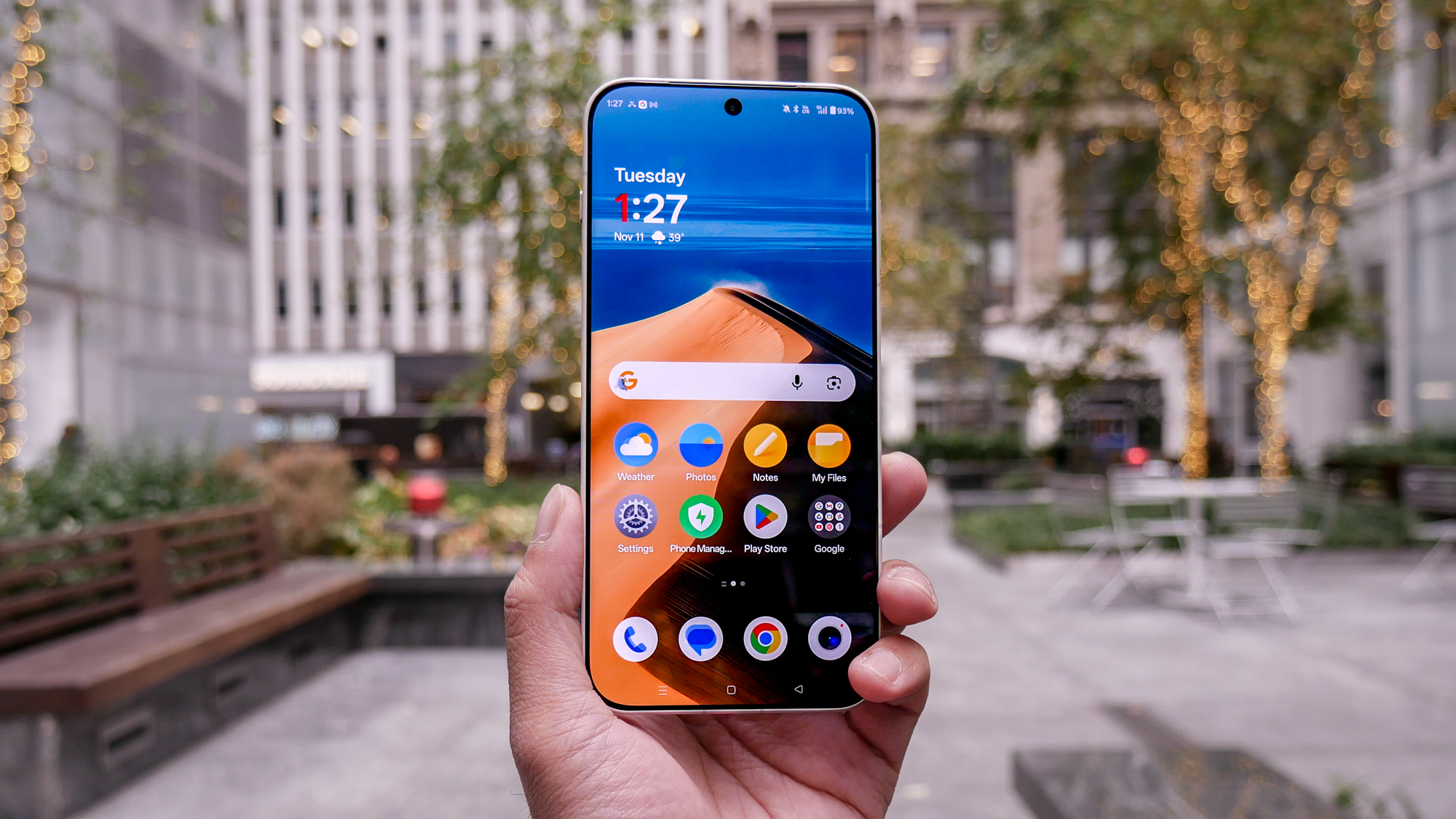 OnePlus 15 held in the hand showing home screen.