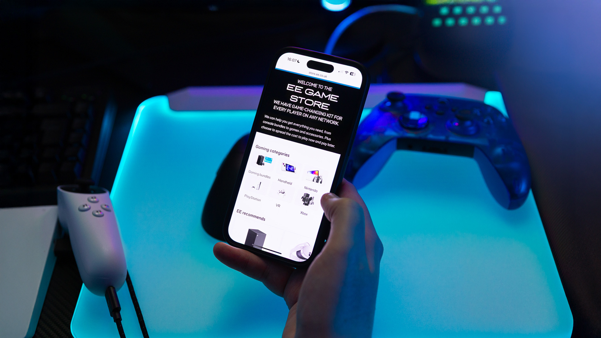 The EE store on a mobile phone, with a gaming controller behind