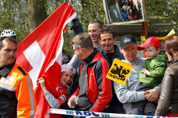 A young Fabian Cancellara fans peers out from within the crowd