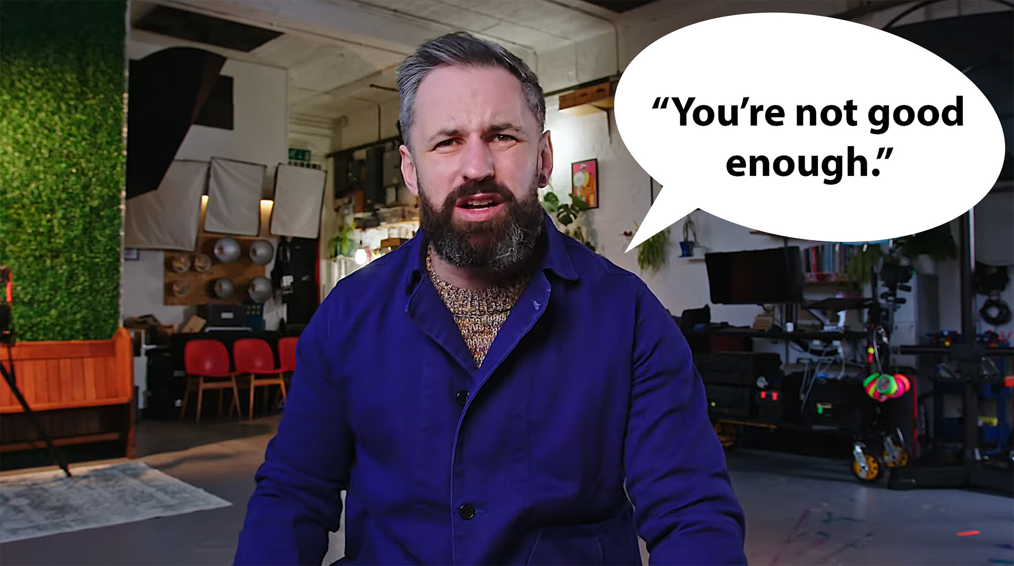 Screen shot from Scott Choucino video with Scott wearing a blue top in a photo studio with speech bubble saying "You're not good enough."