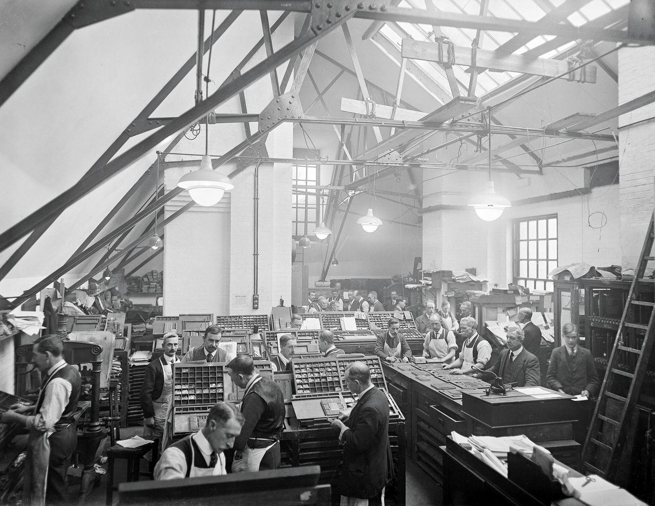 The typesetting room in the roof space in 1920. A version of this photograph was also taken without lights or people.