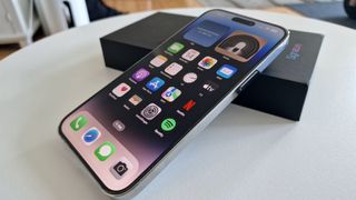 iPhone 14 Pro Max ligger på et bord oven på Swappie-æsken