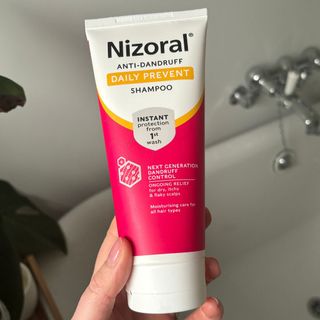 Laura holding Nizoral Anti-Dandruff Daily Prevent Shampoo