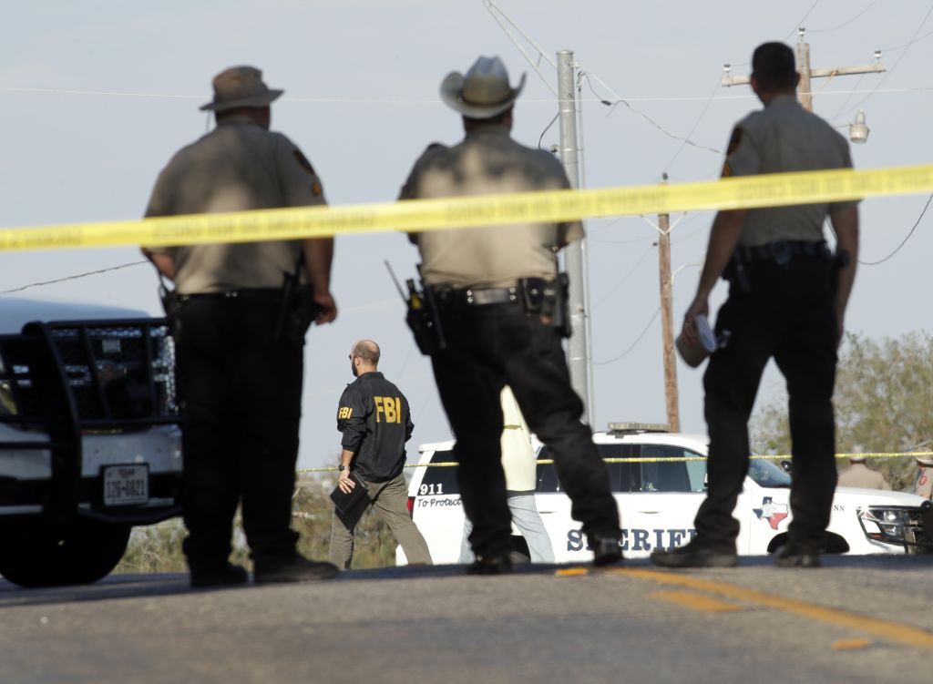 Law enforcement officials gather near the First Baptist Church at Sutherland Springs.