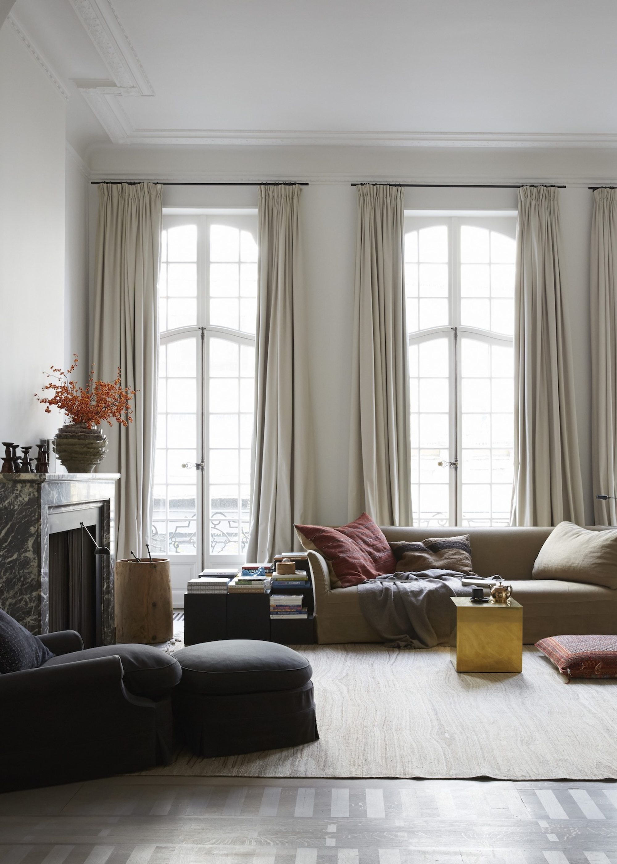 double height curtains in a living room beside a large sofa