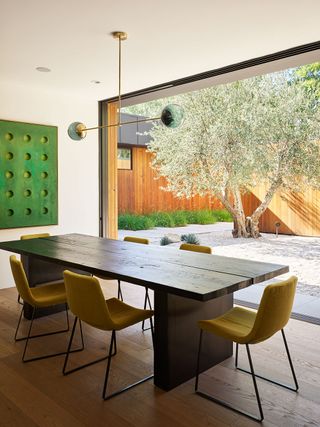 Modern dining room with floor to ceiling windows and views into courtyard