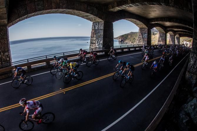 Riders pass through a tunnel along the coast