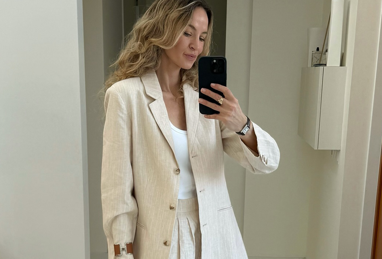 Woman wearing white best bodysuit with blazer and linen pants.