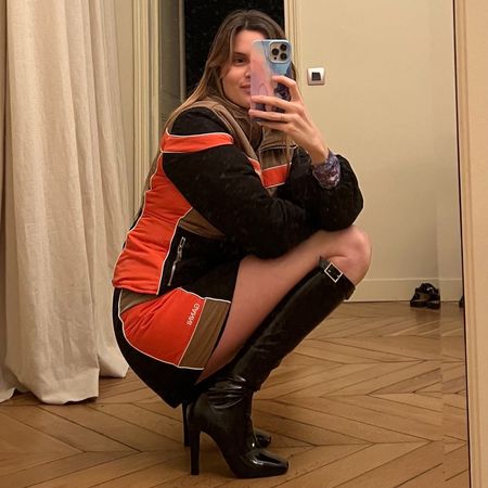 French editor and writer Eug&eacute;nie Trochu poses in a Ganni with black heeled knee-high boots