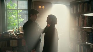 Penn Badgley touches Madeline Brewer's face in a book store in You