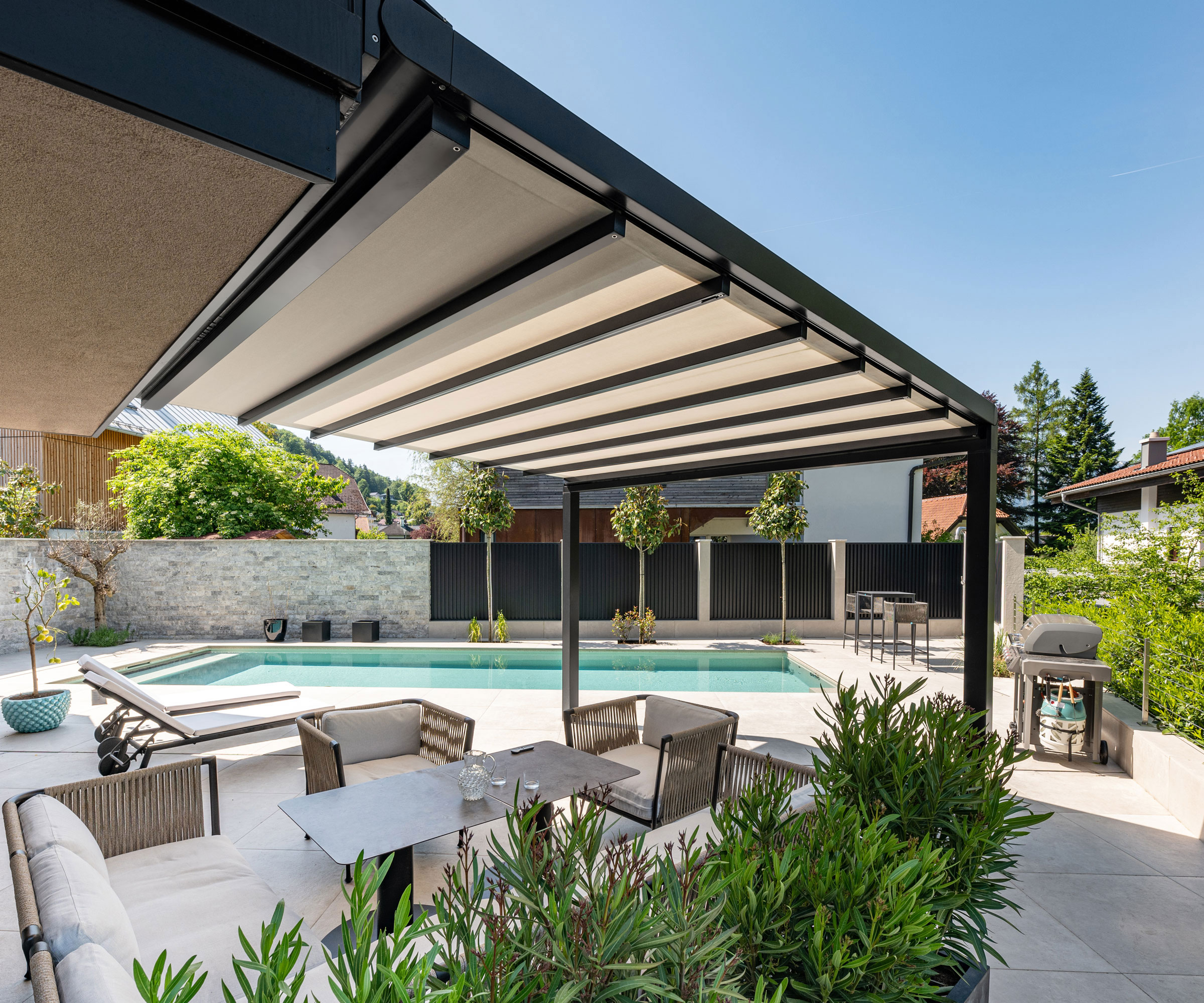 patio awning cover with garden furniture, swimming pool, outdoor cooker and trees