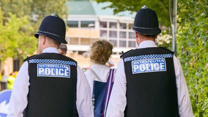Rear view of two police officers of the Metropolitan Police patrolling the roads outside the All England Lawn Tennis Club during the championship event.