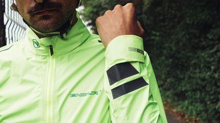 A white man with facial hair in a day glow yellow waterproof cycling jacket
