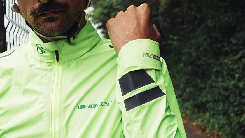 A white man with facial hair in a day glow yellow waterproof cycling jacket