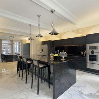 white kitchen with black marble cabinet and white flooring