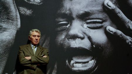 GCAB0H Photographer Don McCullin stands in front of one of his photographs on display in the Shaped by War exhibition at the Imperial War Museum North in Manchester.