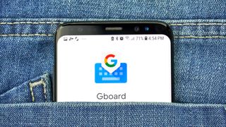 Gboard app on a phone screen sitting in a jean pocket