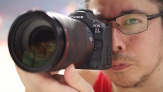 Photographer James Artaius using a Canon EOS R5 Mark II in front of a basketball game