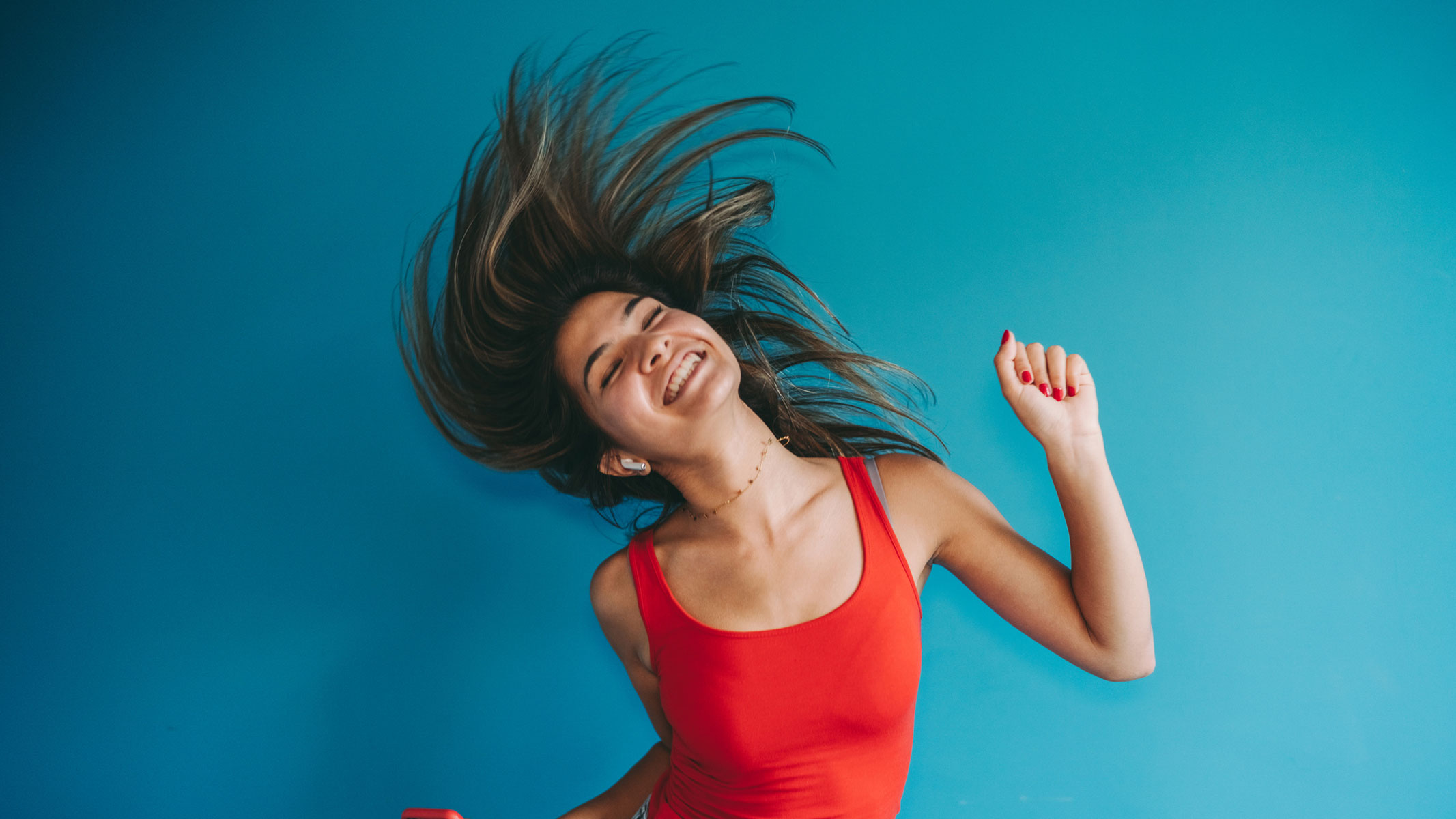 A young woman dancing with earbuds