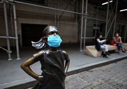 Fearless Girl statue outside the U.S. stock exchange wears a mask.
