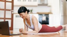 Woman doing plank variations on floor of living room at home