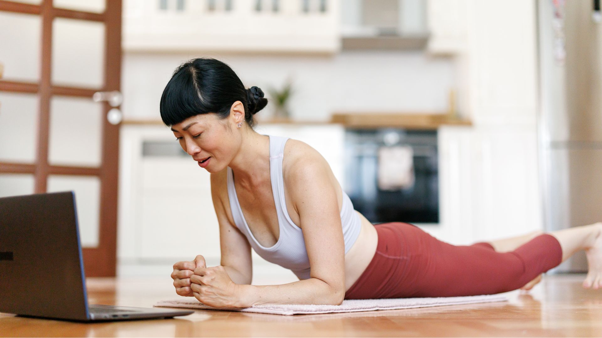 Woman doing plank variations on floor of living room at home