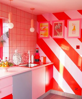 Pink and red kitchen with candy stripe wall decor and framed wall art