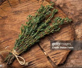 bunch of thyme on wooden chopping board