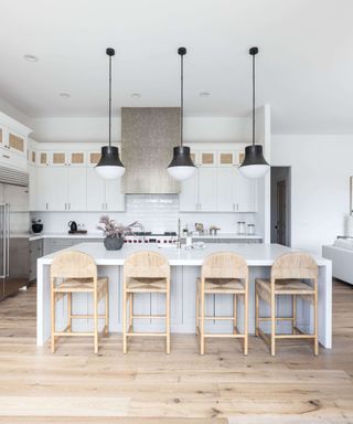 White modern kitchen with kitchen island and black pendant lighting