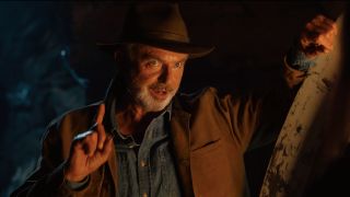 Sam Neill giving some advice in a darkened tunnel in Jurassic World Dominion.