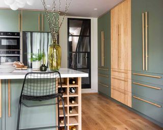 green kitchen with wooden pantry and gold handles