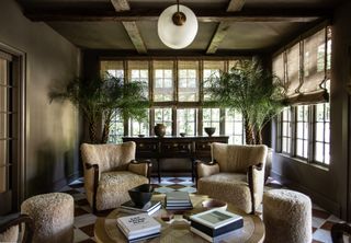 Brown and white stone floor, fluffy armchairs and stools, plants