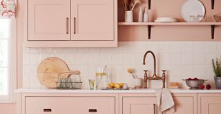 Blush pink kitchen with copper bronze cabinets handles that match the tap to show how to make a kitchen look expensive on a budget