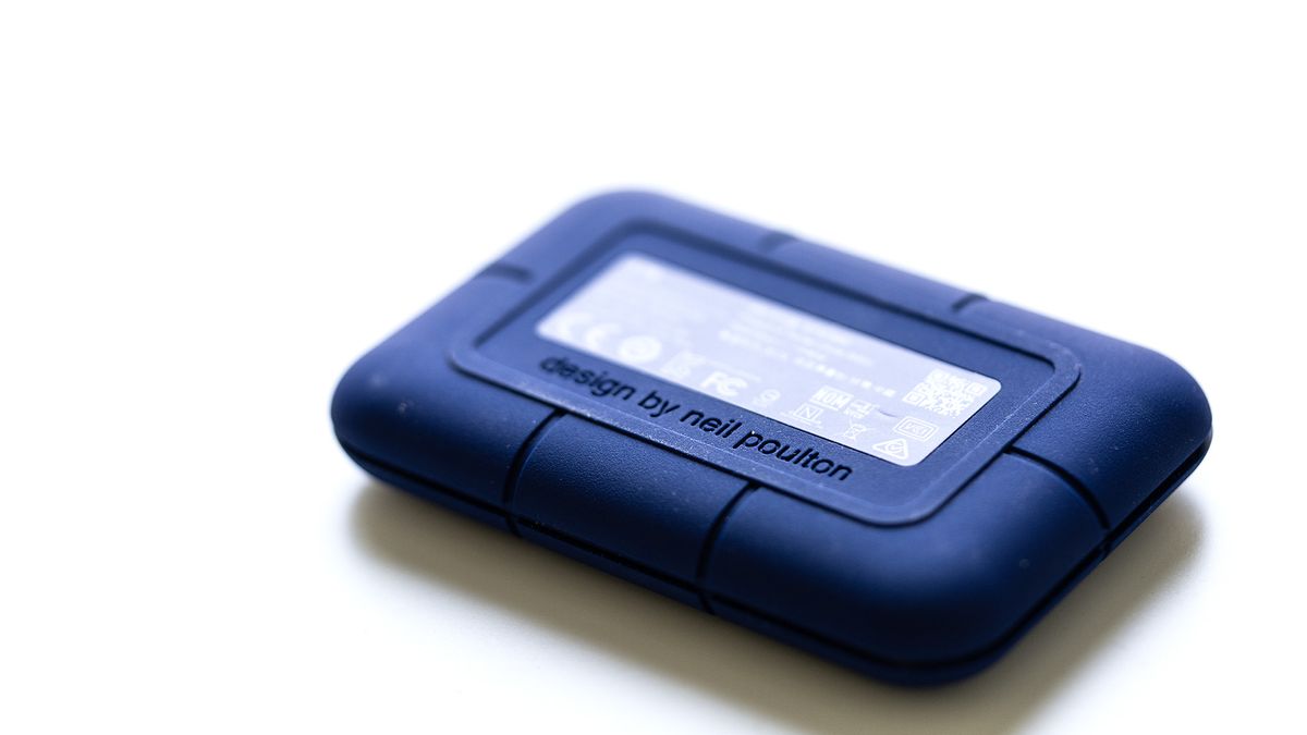 The LaCie Rugged Pro 5 in blue on a laptop and on a white background.