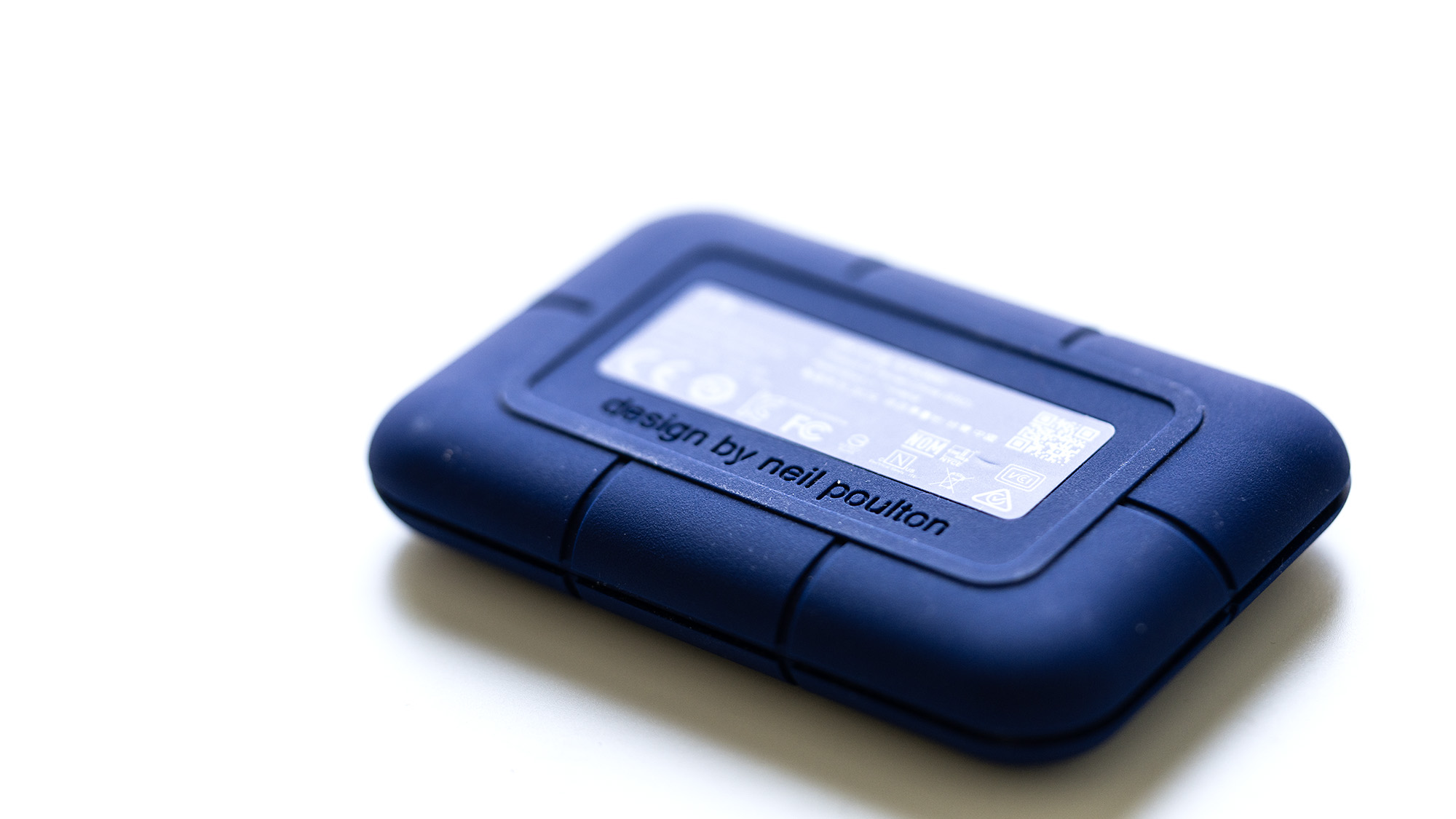 The LaCie Rugged Pro 5 in blue on a laptop and on a white background.