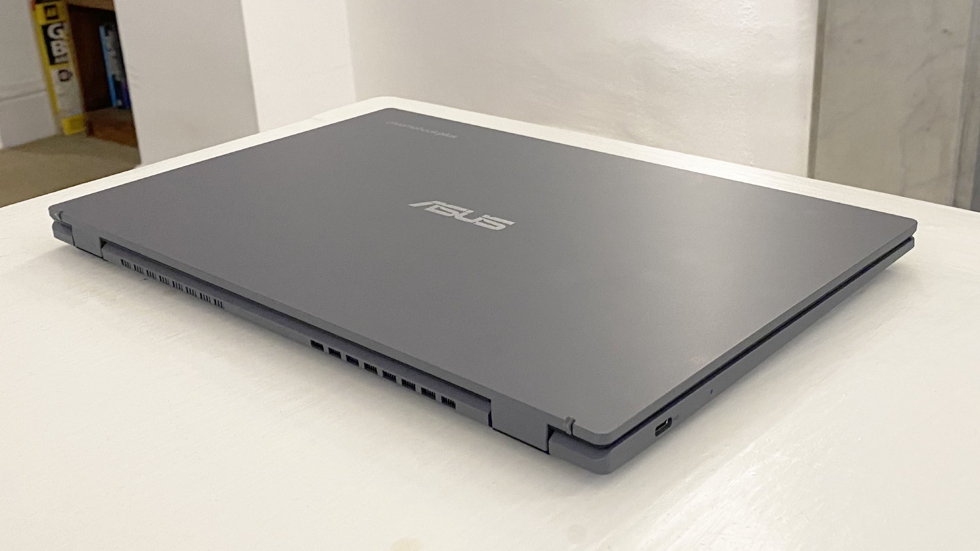The Asus Chromebook Plus CX34 photographed on a white desk.