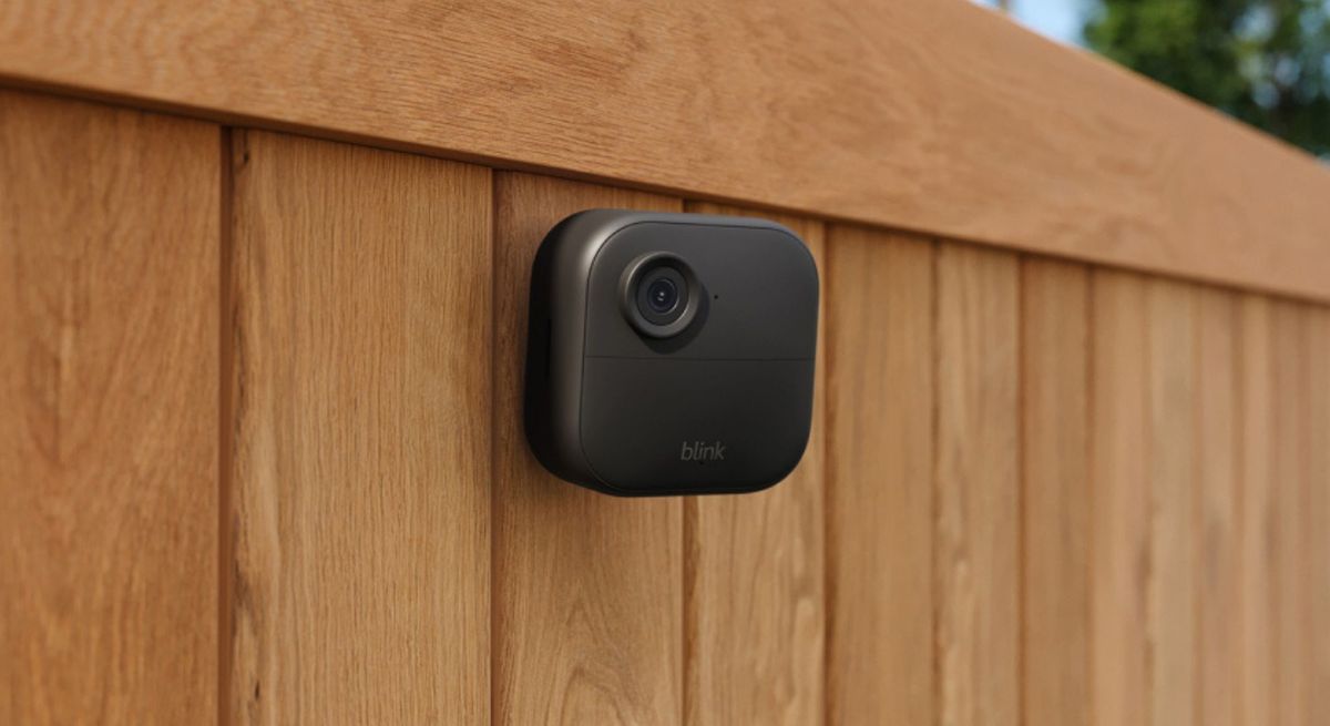The Blink Outdoor 4 being used outdoors, attached to a fence