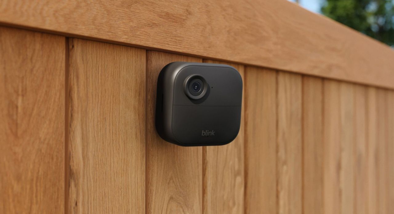 The Blink Outdoor 4 being used outdoors, attached to a fence