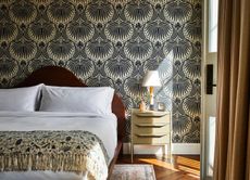 a bedroom with decorative blue and cream wallpaper