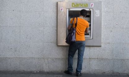 A man withdraws cash from a Bankia ATM in Madrid: Spain's third-largest bank has requested a $24 billion bailout.